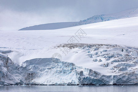 白蓝冰川舌头直接落到南极平静的海面上分层山脉南极洲图片