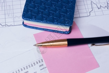 白色的文件用于书写财务图形报告的笔和纸叠财务报表上的笔商业背景标记图片