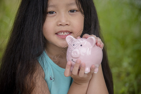 女可爱的孩子在小猪银行存着硬币快乐的小投资为幸福的未来储蓄钱快乐的孩子们笑得开心的姑娘财政女孩图片