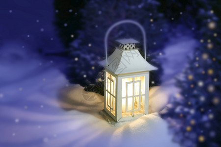 橙雪中的白色圣诞灯笼黄蜡烛光以神秘的紫罗兰背景白色的雪堆图片