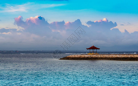 逃脱日落时分在开阔水域的巴厘岛凉亭岩石自然背景图片