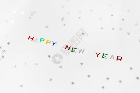 复制用多色闪亮字母书写的新年快乐以及银色星新年贺卡用多彩闪亮字母书写的新年快乐铭文以及银色星新年贺卡字体书面图片