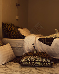 木制的枕头和毯子在床上有温暖的灯光枕头和床毛毯在上放松窗户背景图片