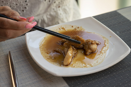 女人在餐厅吃亚洲菜鸡肉加和铁谷辣酱汤匙加勺子丰富多彩的晚餐东方图片