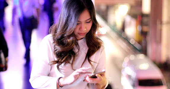 美丽的年轻亚洲女在夜间使用手机的户外肖像画女青年夜晚技术士图片