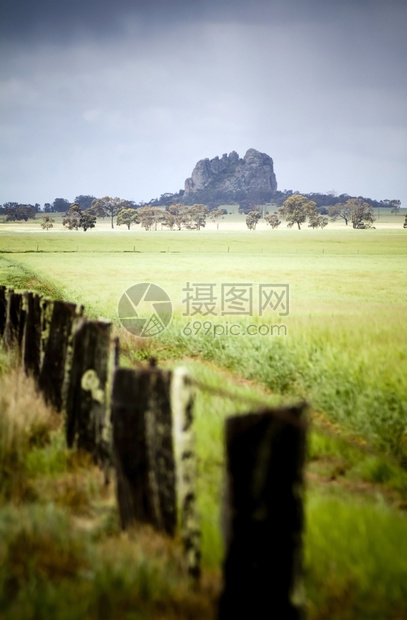 站立密特罗克独自站在一个有旧围栏的田地后面山农业图片