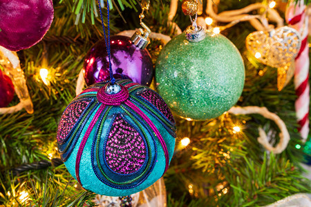 十二月庆祝圣诞树装饰着紫色和青黄的主题装饰球和蜡烛灯明着装饰图片