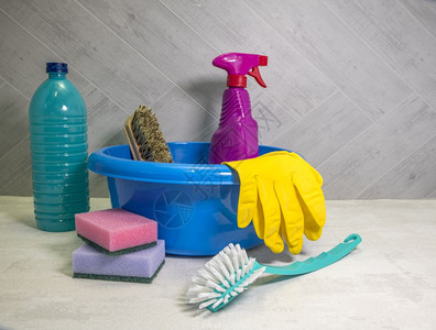 家庭主妇带有清洁工具的蓝色洗碗盘和作为脱脂剂的洗涤和带抹布的刷子清洁工具的洗碗盘白色图片