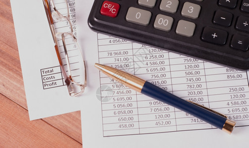 文件位于财务报表的计算器笔和眼镜印在财务报表上的计算机笔和眼镜预算经济图片