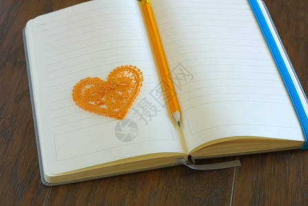 迷人的书笔记纸红心符号在笔记本上用铅写在打开的空白笔记本页面图片