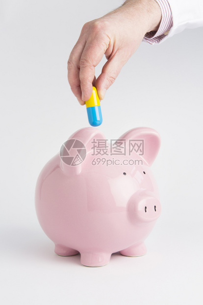 成本将胶囊放入小猪银行PigBank卫生保健图片