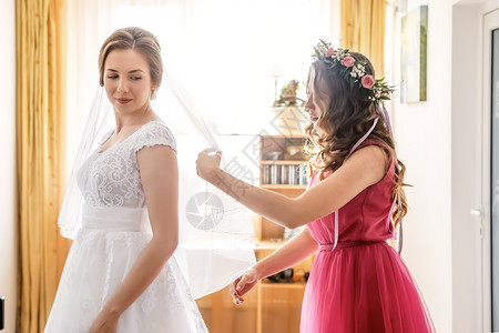 年轻的裙子帮助新娘穿上婚纱的女图片