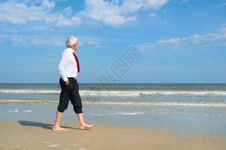 穿正式西装的商人在海滩散步夏天娱乐自然图片