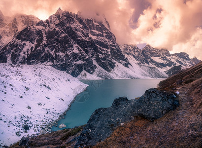 攀登美丽的多云山湖雪和喜马拉雅山峰的日落景观图片