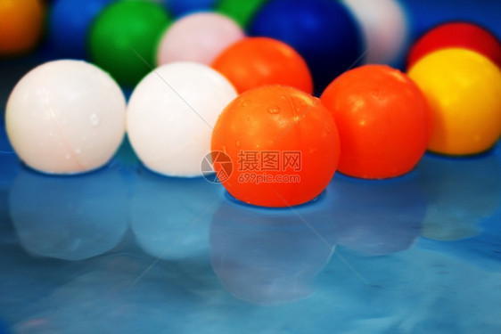 混合蓝水背景下儿童泳池中的塑料彩球儿童泳池中的塑料彩球玩具喜悦图片
