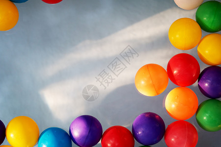 孩子们的红色婴儿蓝水背景下童泳池中的塑料彩球儿童泳池中的塑料彩球图片
