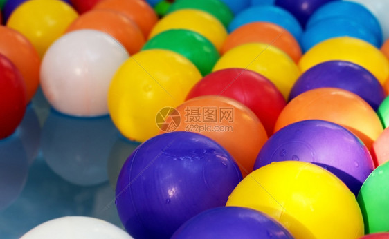 喜悦儿童游泳池中蓝水背景的彩色球在儿童游泳池中可塑化彩色球的背景上目孩子们图片