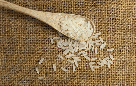 食物粮以粗布为背景的木勺子中亚洲未煮白米传统的图片