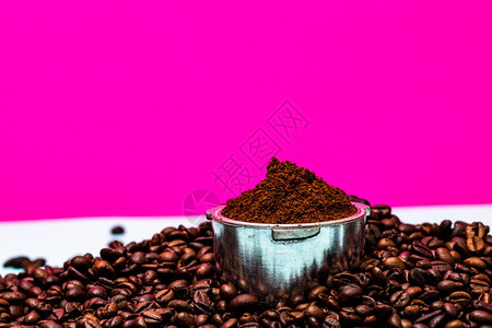 咖啡店豆和脚过滤器以粉红背景的成份制地面咖啡质豆子图片