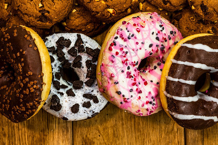 烘烤的白色糖巧克力薯片饼干和多彩甜圈的顶层视图和背景面粉甜圈和饼干图片