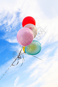 阳光氦明亮的蓝色天空背景上的多彩气球图片