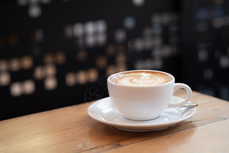 艺术浓咖啡厅的木制桌子上一个白色杯中的咖啡拿铁店图片