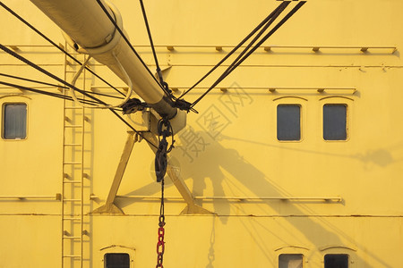 黄帆船和海上运输车辆概念中带有生锈吊起重机和绳索的旧高隆起重机一部分泰国血管工业的背景