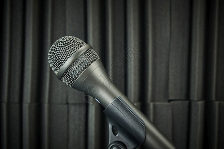 声音专业的娱乐用灰色调装在麦克风台和声波泡沫背景上的侧面麦克风背景图片