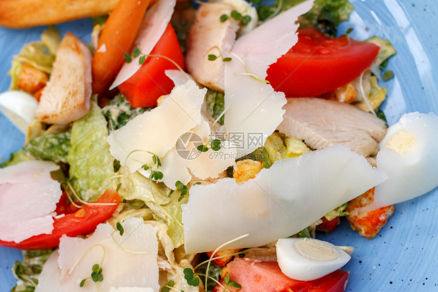 碗鲜鸡沙拉新蔬菜和奶酪蓝底色的烤鸡沙拉莴苣面包图片