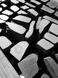 在一条城市行人街道上丢石头形成黑白对比光的图案黑色和白英国建筑学阴影图片