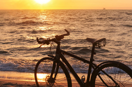 日落海滩上的自行车图片