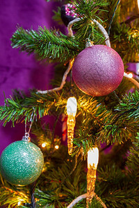 紧贴一棵圣诞树在紫色主题下装饰有突出的紫色青彩球和蜡烛灯传统的装饰风格绿色图片