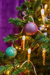 紧贴一棵圣诞树在紫色主题下装饰有突出的紫色青彩球和蜡烛灯电泡内部的装饰风格图片