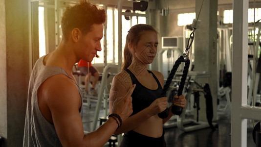 训练肌肉帮助体操中从事重哑铃工作的妇女个人教练员力量图片