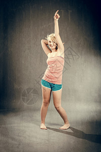 吸引人的移动时尚感金发女郎短裤跳舞的照片图片