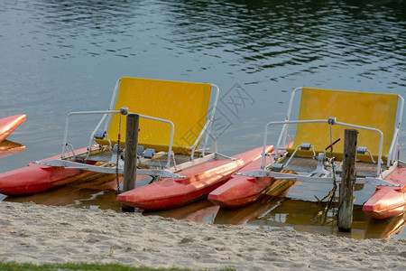 孩子们海滩蓝色的湖上小便或划桨自行车图片