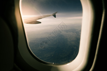 飞机内仓云景从飞机内日落的景象穿过西班牙山上翅膀的窗外多于景观背景