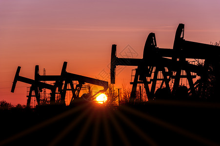 机械工业的日落天空背景时在油田上的泵插孔气工业概念千斤顶图片
