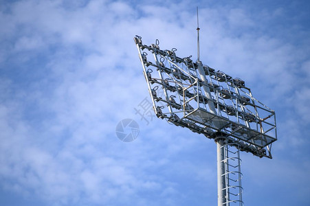 电极以蓝天空背景足球和灯的体育场聚光灯高的图片