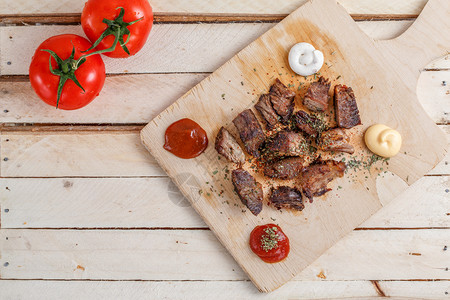 烤肉片和木盘上香料的烤肉配有四类酱和西红柿烧烤种类牛腩背景图片