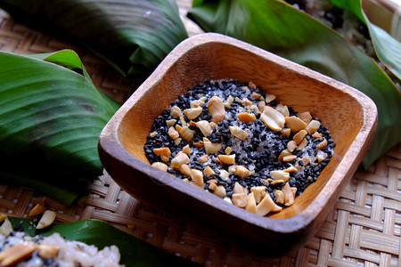 白色的越南人自制黑豆粘糊米配有芝麻盐在白底竹子篮上以绿色叶快速早餐食物颜色图片