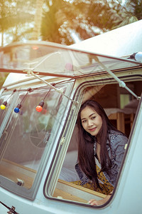 旅行夏日坐在野营车里的美丽年轻女士屋露营车图片