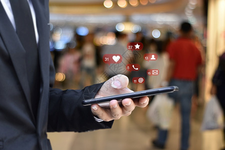 利用移动智能手机与社交媒体图标使用移动智能手机的商人关系密切机场站背景模糊商业技术或社交网络概念商业技术或社交网络概念信息电脑全图片