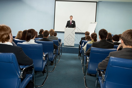 屏幕讲师称呼成功的商人在业会议上与听众交谈在商业会议中图片