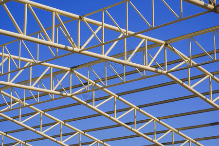 蓝色天空背景下建筑区黄金属屋顶结构的低角度视图以蓝天背景为单位工程仓库泰国图片