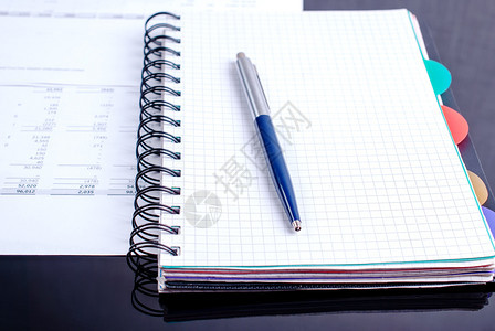 投资帐户商务配件笔记本黑桌上的文件带蓝笔记事本和黑桌上的财务文件办公室图片