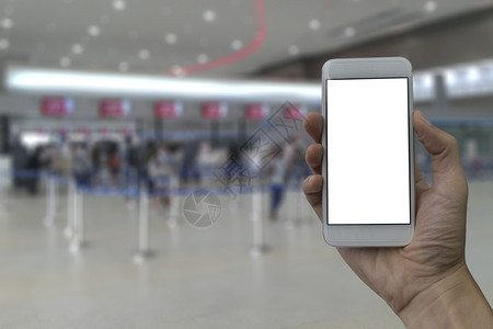 离开游客手持智能机用白色空屏幕在模糊的填入背景面上持有智能手机票图片