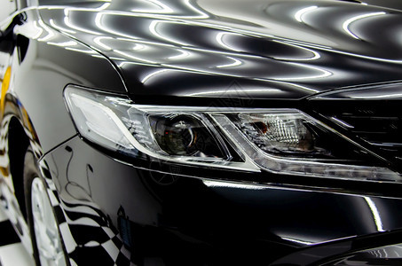 现代的正面卤素汽车细节奢华的现代车灯和闪亮的黑色汽车帽子图片