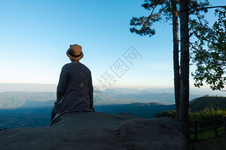 假期年轻的亚洲妇女独自坐在公园的岩石上情绪图片