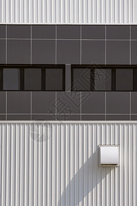 建造当代的棕色办公室玻璃窗户一行的垂直框中现代工业建筑白色金属墙壁上的烘干机通风口垂直的图片
